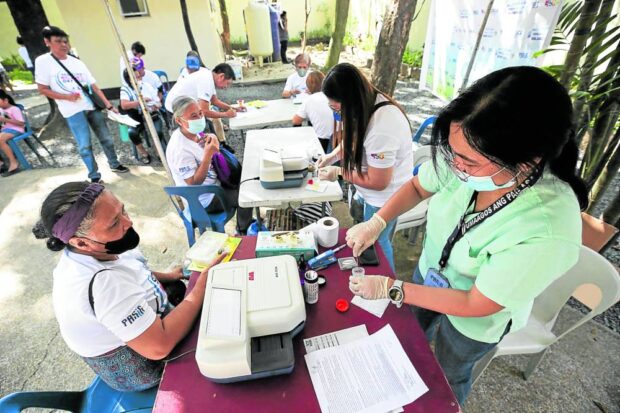 OVERWORKED, BUT UNDERPAID A nurse tests the urine specimen given by a senior citizen to check for kidney disease at Urine Alkaline Creatinine Rate station. The free service was done on Senior Citizens’ Wellness Day 2023 held at Maybunga Rainforest Park in Pasig City. —LYN RILLON
