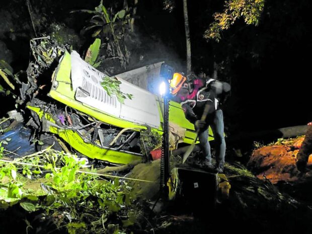 DEADLY CURVE A team of rescuers works through the night on Tuesday to retrieve passengers who died or were injured after a bus overshoots a curve and falls into a ravine in Hamtic, Antique.