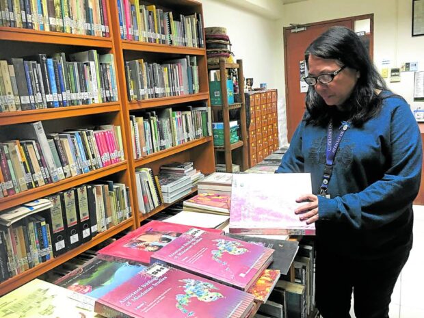 MINDANAO BOOKS Perpy Vina, director of Mindanawon, thumbs through copies of “Annotated Bibliography of Mindanao Studies,” which contains a comprehensive listing of all books written about Mindanao, a project initiated by former University of the Philippines Mindanao chancellor Ricky de Ungria, which the organization supported. 