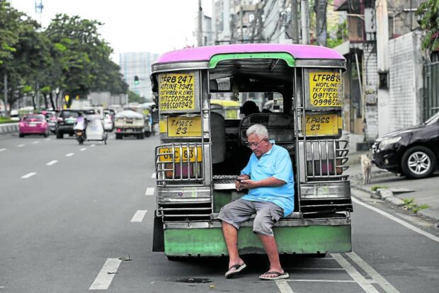 SHORT BREAK An elderly jeepney driver rests in between trips along Visayas Avenue in Quezon City in this photo taken in October. —LYN RILLON