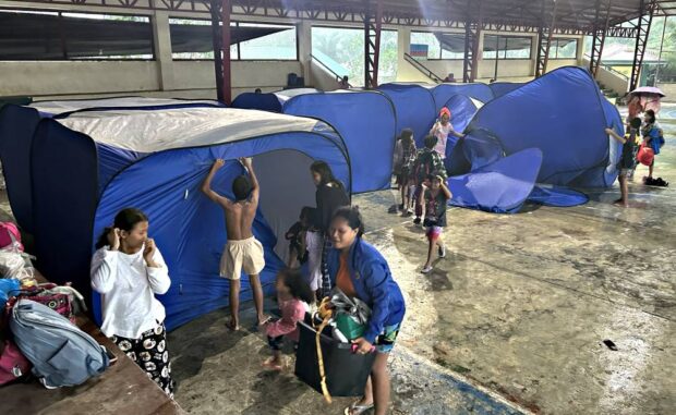 SAFE SPACE Residents forced to leave their homes by heavy rains brought about by Tropical Storm“Kabayan” prepare their tents inside a covered court at Barangay Patin-ay in Prosperidad, Agusan del Sur, on Monday. —ERWIN MASCARIÑAS