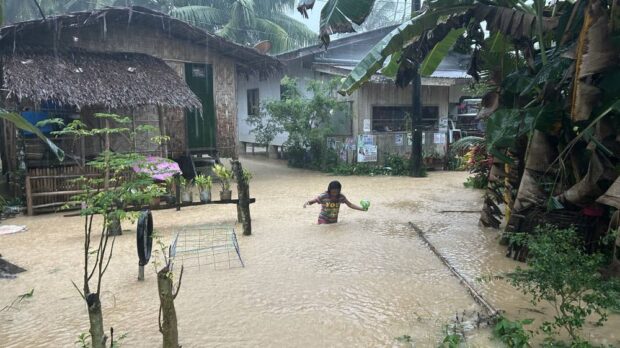 MURKY CROSSING A girl wades through waist-deep floodwater in her village in Prosperidad town, Agusan del Sur, on Monday after heavy rains dumped by Tropical Storm “Kabayan” submerged roads and houses in the community, displacing hundreds of residents. —ERWIN MASCARIÑAS