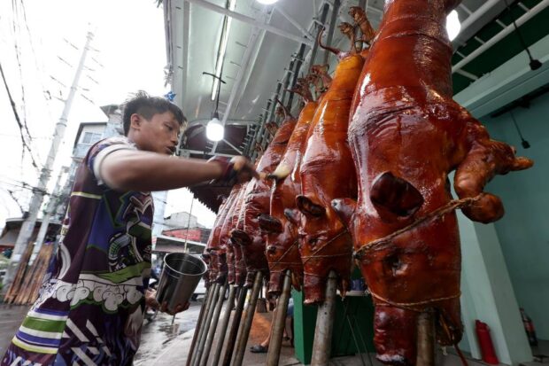 HOLIDAY FARE “Lechon” (roast pig) sellers in La Loma, Quezon City, expect sales to be brisk as Christmas Day nears. Doctors, however, warn revelers to watch their food and alcohol intake to avoid health problems related to the Christmas and New Year celebrations. —GRIG. C. MONTEGRANDE