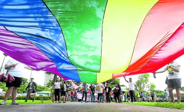 Lesbians, gays, bisexuals and transgenders assemble at Rizal Park to prepare for their 21st Metro Manila Pride March on June 27, 2015, with a massive rainbow banner that symbolizes their community.  lgbtq marcos