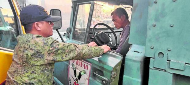 Crenenandy Cadiente, 44, (seated on the driver's seat of KM450), is arrested on Sunday after two persons were killed when he took over wheel of an unattended military truck of Task Force Davao, which mowed though marketgoers early morning of Dec. 24.  military truck davao