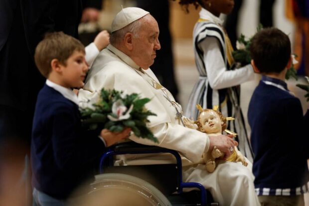Pope Francis holds a figure ofbaby Jesus during celebration of Christmas Eve Mass in St. Peter’s Basilica at the Vatican. 