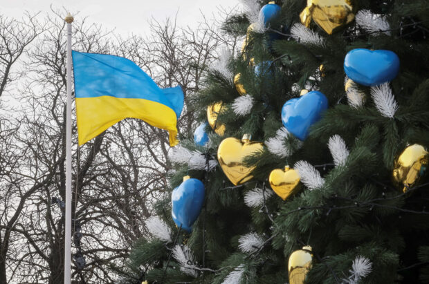 A view shows a Christmas tree near a Ukrainian national flag in Kyiv