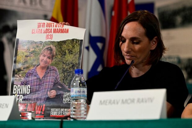 Israeli citizen Maayan Sigal-Koren holds a sign depicting Clara Rosa Marman, 63, held hostage by Hamas 