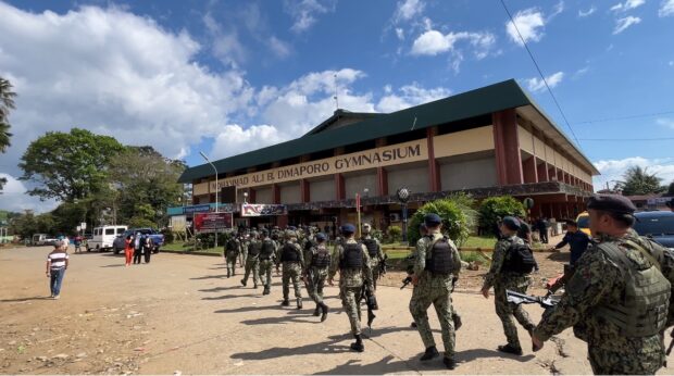 TIGHT SECURITY Policemen patrol the Mindanao State University campus in Marawi City on Monday, a day after the bomb attack at Mohammad Ali B. Dimaporo Gymnasium while a Catholic Mass was being celebrated. More policemen and soldiers have been sent to the Lanao del Sur provincial capital to secure the campus. —LEAH D. AGONOY