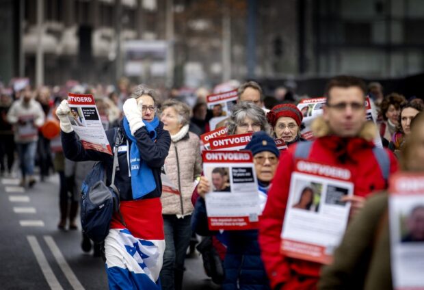 Protestors hold signs during a silent procession, organized by Christians for Israel and the Center for Information and Documentation Israel (CIDI), near the House of Representatives in The Hague, on December 7, 2023.