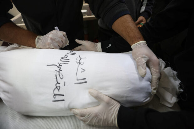 In Gaza, rows of white shrouds symbolize mounting civilian deaths