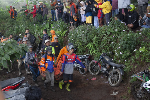 Rescuers carry the body of a victim of the eruption of Mount Marapi in Batu Palano, West Sumatra, Indonesia, Tuesday, Dec. 5, 2023. Rescuers searching the hazardous slopes of the volcano found more bodies of climbers who were caught by a surprise weekend eruption, raising the number of confirmed dead to nearly two dozens, officials said Tuesday. (AP Photo/Sigit Putra)