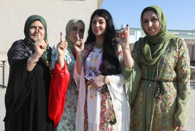 Kurdish women show their ink-stained fingers after casting votes during Iraq's provincial council elections, at a polling station in Kirkuk
