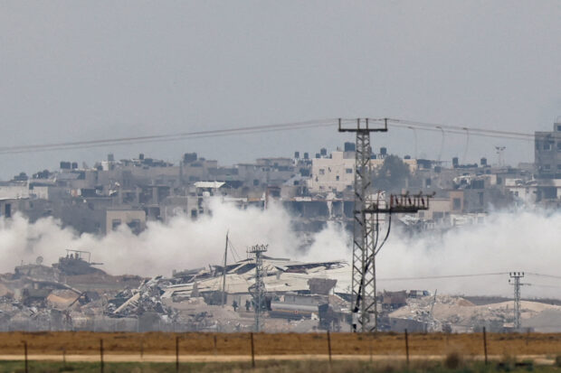 An Israeli military tank and soldiers operate in the Gaza Strip, as seen from southern Israel
