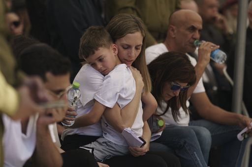 Relatives of Israeli Col. Asaf Hamami mourn during his funeral at the Kiryat Shaul military cemetery, in Tel Aviv, Israel, Monday, Dec. 4, 2023. Hamami, the commander of the Gaza Division's Southern Brigade, was killed on Oct. 7, in the unprecedented, multi-front attack on Israel by the militant group Hamas that rules Gaza. and his remains are being held in the Gaza Strip, the Israeli military said. (AP Photo/Leo Correa)