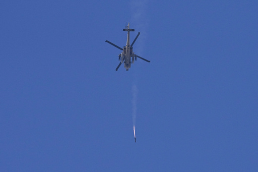 An Israeli Apache helicopter fires a missile in direction of the Gaza Strip, as seen from southern Israel, Monday, Dec. 4, 2023. (AP Photo/Ohad Zwigenberg)