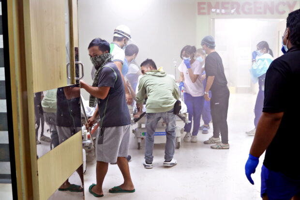 EVACUATION Patients of Manuel J. Santos Hospital in Butuan City are evacuated to the street outside the hospital after a magnitude 7.4 earthquake caused a part of the hospital building to catch fire. —ERWIN MASCARIÑAS