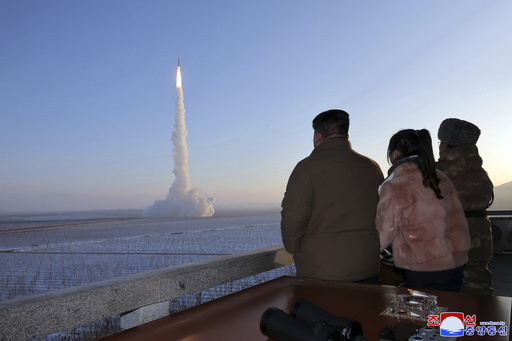 In this undated photo provided Monday, Dec. 18, 2023, by the North Korean government, North Korean leader Kim Jong Un, his daughter and an official watch what it says is an intercontinental ballistic missile launching from an undisclosed location in North Korea.