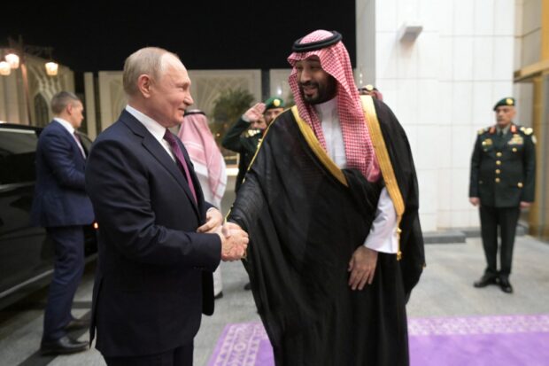 This pool photograph distributed by Russian state agency Sputnik shows Russia's President Vladimir Putin shaking hands with Saudi Crown Prince Mohammed bin Salman ahead of their talks in Riyadh on December 6, 2023. 