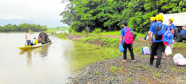 RIVER CROSSING   Rescuers on Saturday cross this river in Palanan, Isabela, as they head to the town’s forested area within the Sierra Madre mountain ranges to search for the Cessna plane that  disappeared minutes after it took off from Cauayan Airport on Nov. 30.  —PHOTO COURTESY OF THE PALANAN MUNICIPAL DISASTER RISK REDUCTION MANAGEMENT OFFICE