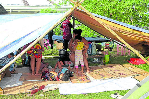 SAFER HERE Residents of Barangay Bitoon in Hinatuan, Surigao del Sur, on Monday set up makeshift shelters in a school ground for fear of staying in their houses, which might give way to strong aftershocks in the wake of Saturday’s magnitude 7.4 earthquake. —ERWIN M. MASCARIÑAS