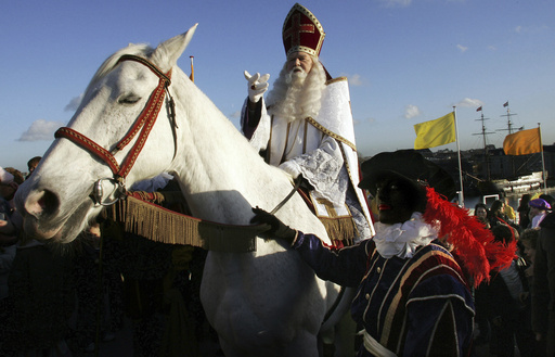 FILE - Sinterklaas, the Dutch equivalent of Santa Claus, and his helper, "Zwarte Piet" or "Black Pete" arrives at the roof of the Nemo Museum in Amsterdam, Netherlands, Wednesday, Nov. 29, 2006. Dutch Protestants who settled in New York brought the memory of Sinterklaas in the 17th century to New Amsterdam. (AP Photo/ Evert Elzinga, File)
