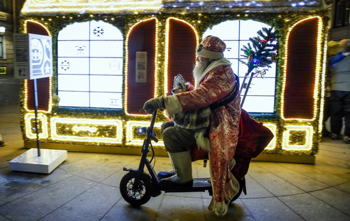 FILE - A man dressed as Ded Moroz (Grandfather Frost), the Russian Santa Claus, rides an electric scooter by a street decorated for the incoming New Year and Orthodox Christmas celebrations in St. Petersburg, Russia, Tuesday, Dec. 17, 2019. (AP Photo/Dmitri Lovetsky, File)