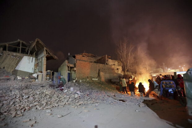 Residents gather near a bonfire for warmth in freezing conditions in the aftermath of an earthquake in Kangdiao village of Jishishan county in northwestern China's Gansu province Tuesday, Dec. 19, 2023. An overnight earthquake killed multiple people in a cold and mountainous region in northwestern China, the country's state media reported Tuesday.(Chinatopix via AP)
