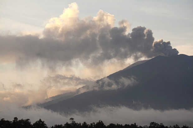 Mount Marapi spews volcanic materials during its eruption as seen from Tanah Datar, West Sumatra, Indonesia, Friday, Dec. 22, 2023. Volcanic ash spewing from the nearly 2,900-meter (9,480-foot) volcano shut down airports and blanketed nearby communities on Sumatra island Friday. (AP Photo/Ali Nayaka)