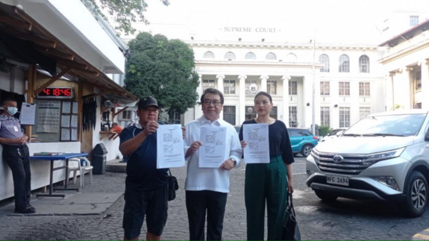 Transport group Piston National President Mody Floranda (left), counsel Atty. Neri Colmenares (center), and Atty. Krissy Conti of the National Union of Peoples’ Lawyers- National Capital Region (right) pose in front of the Supreme Court on Thursday, December 28, after filing a supplemental motion seeking to speed up the court’s decision on the previous appeal to block the December 31 deadline for the franchise consolidation of public utility vehicles in the country.