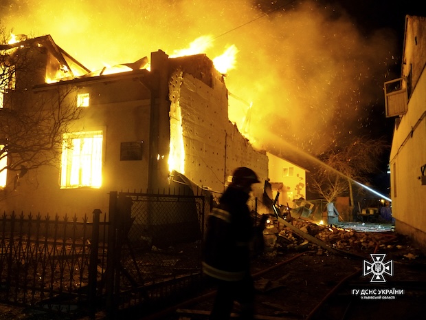 In this photo provided by the Ukrainian Emergency Service, firefighters work on the site of a burning building after a Russian drone attack in Dublyany, Lviv region, Ukraine, Monday, Jan. 1, 2024. 