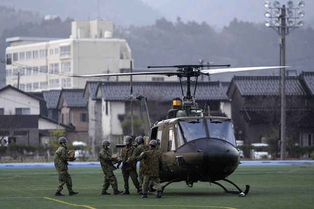 Members of the Japan Ground Self-Defense Force load relief goods into its helicopter before taking off from a temporary landing site in Wajima in the Noto peninsula, facing the Sea of Japan, northwest of Tokyo, Saturday, Jan. 6, 2024, following Monday's deadly earthquake. 