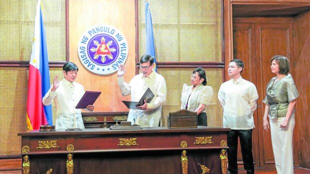 THE ECONOMY ON THEIR MINDS President Marcos administers the oath of office to newly appointed Finance Secretary Ralph Recto (upper photo) and Secretary Frederick Go who will serve as special assistant to the President for investment and economic affairs, beside members of their respective families in Malacañang on Friday. —MALACAñANG PHOTO
