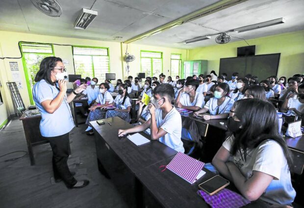 PHOTO: A teacher conducting a face-to-face lesson on different types of advocacy for learners of Navotas National High School. STORY: House bill seeks P15,000 medical allowance for teachers