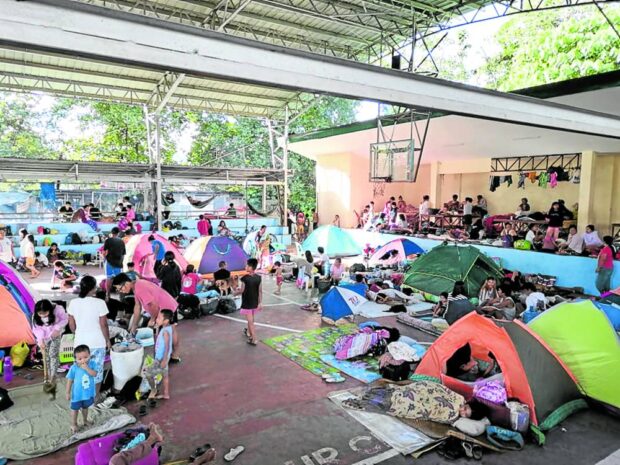 Families from Jade Valley and JulivilleSubdivisions at Barangay Tigatto in Davao City seek temporary shelter in a covered court in the village after floodwaters swamped their homes on Thursday night.