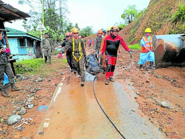  Rescuers carry the remains of one of the victims of a landslide at Barangay Mt. Diwata in Monkayo, Davao de Oro, as search and retrieval operations continue on Friday. 
