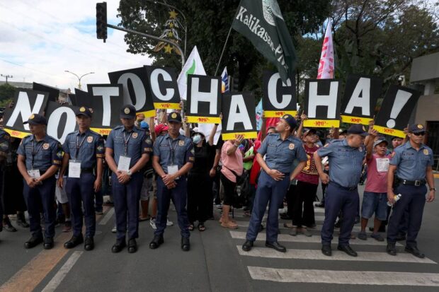 OUTCRY Policemen are on standby as groups allied with the Bagong Alyansang Makabayan stage a protest in front of the House of Representatives inQuezon City onMonday to condemn what they call the “self-serving” Charter change initiative promoted by leaders of the lower chamber. —GRIG C.MONTEGRANDE