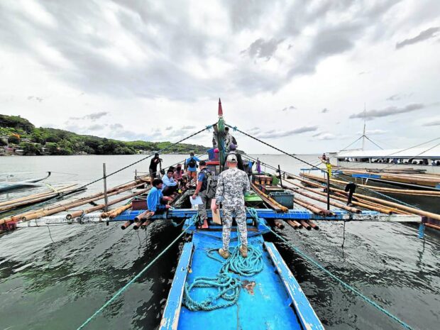 BLAST FISHING A Philippine Coast Guard member inspects a fishing boat loaded with blast fishing paraphernalia in Mauban town, Quezon province, in this photo taken in August 2023. Illegal fishing, however, continues in Quezon waters despite efforts to stop it. —PCG-SOUTHERN TAGALOG DISTRICT PHOTO