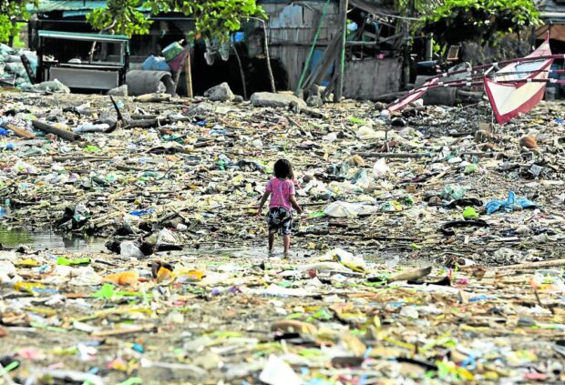 COASTAL CLEANUP A child plays amid garbage on Baseco beach in Tondo, Manila, during the International Coastal Cleanup day in this photo taken in September 2023. —RICHARD A. REYES