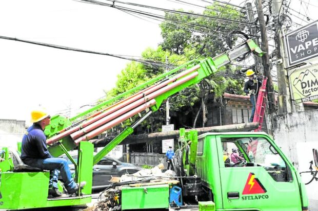 SAFETY FIRST Linemen from the San Fernando Electric Light and Power Co. clear tangled wires and “spaghetti” connections along the power firm’s lines for the safety of the public. The power firm recently gets a legal relief after the Court of Appeals stops an Energy Regulatory Commission order to refund P1.24 billion to its consumers in the provincial capital of Pampanga. —CITY OF SAN FRANCISCO FACEBOOK PHOTO