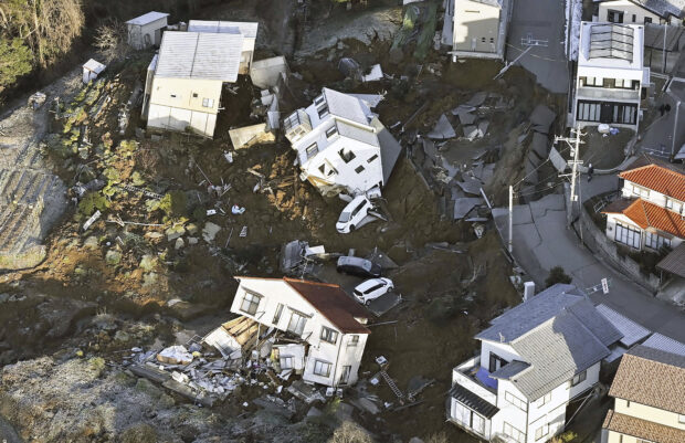 Houses fallen by an earthquake are seen in Kanazawa, Ishikawa prefecture, Japan Tuesday, Jan. 2, 2024. A series of powerful earthquakes in western Japan damaged homes, cars and boats, with officials warning people on Tuesday to stay away from their homes in some areas because of a continuing risk of major quakes and tsunamis. (Kyodo News via AP)