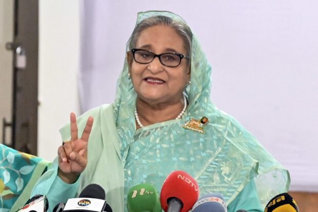 Bangladesh's Prime Minister Sheikh Hasina gestures after casting her vote at a polling station in Dhaka on January 7, 2024. Bangladesh began voting on January 7, in an election guaranteed to give a fifth term in office to Prime Minister Sheikh Hasina, after a boycott led by an opposition party she branded a "terrorist organization". (Photo by AFP)
