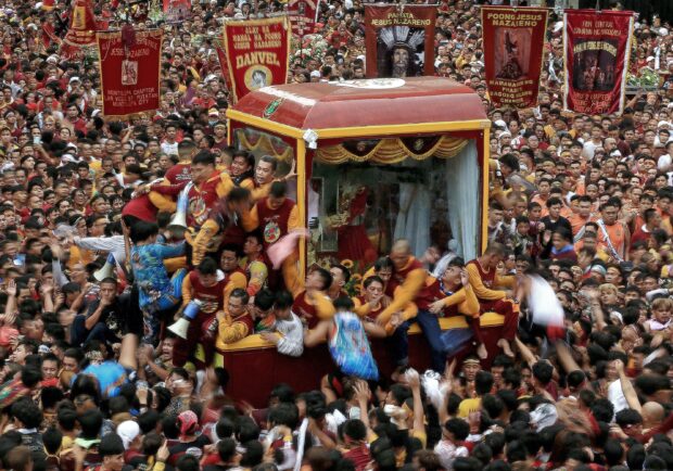 NO BARRIER TO FAITH   In a first in its centuries-old procession, the Black Nazarene is encased in tempered glass to discourage contact with the image amid the threat of a resurgence of COVID-19. But this has not discouraged the crowds escorting the Nazarene on Tuesday’s “traslacion.” —RICHARD A. REYES