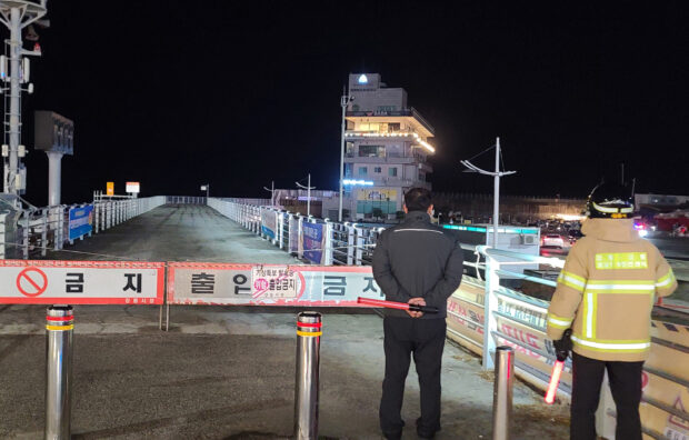 A member of Korea coast guard patrols to watch for possible changes in sea levels on a beach in Gangneung, South Korea