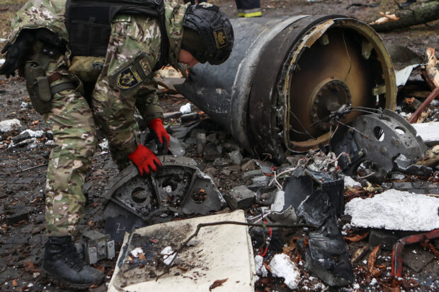 A bomb squad member works next to remains of an unidentified missile at the site where residential buildings were heavily damaged during a Russian missile attack in Kharkiv