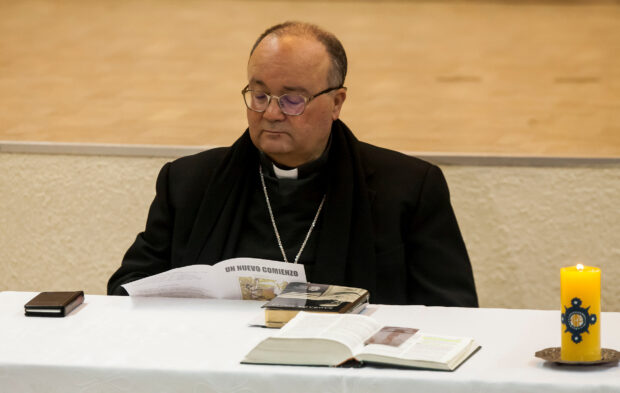 Special Vatican envoys, archbishop Charles Scicluna reads a brochure entitled "A new beginning", during a meeting with priests inside a church in Osorno