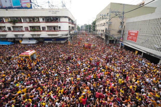 A glass-encased carriage transporting the Black Nazarene winds through a throng during its annual procession in Manila on Tuesday, Jan. 9, 2024, marking its resumption after a three-year hiatus due to the coronavirus pandemic.