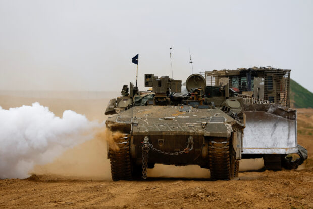 An Israeli armoured personnel carrier (APC) and a D9 bulldozer maneuver near the Israel-Gaza border, amid the ongoing conflict between Israel and the Palestinian Islamist group Hamas, as seen from Israel, February 23, 2024. REUTERS/Susana Vera