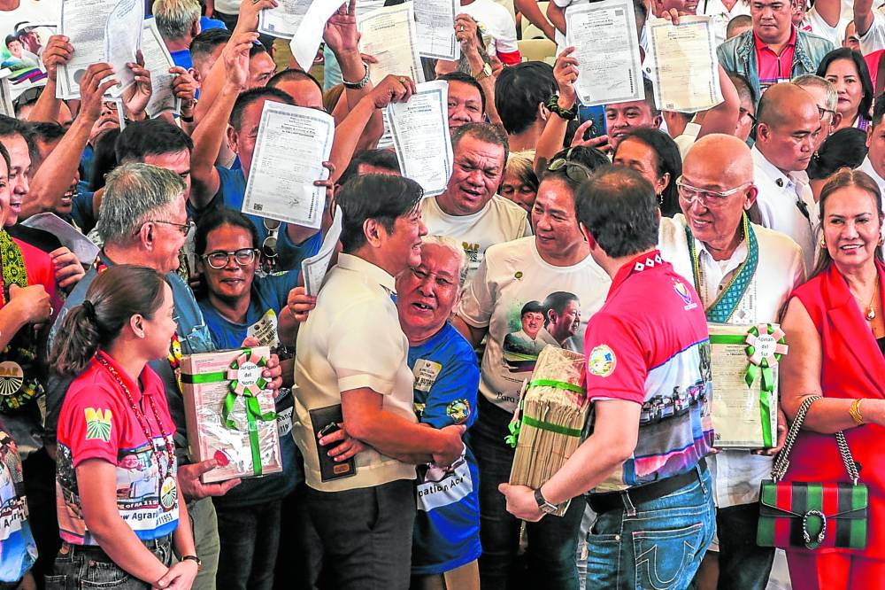  President Marcos congratulates families that werefinally given titles to their lands. 
