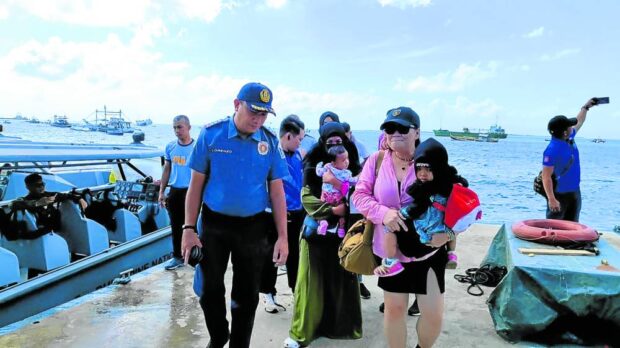 CAPTURED Photo provided by the Presidential Anti-OrganizedCrime Commission shows police on Thursday accompanying
two women, one of them terror suspect Myrna Mabanza,
in Pasil village, Indanan, Sulu.